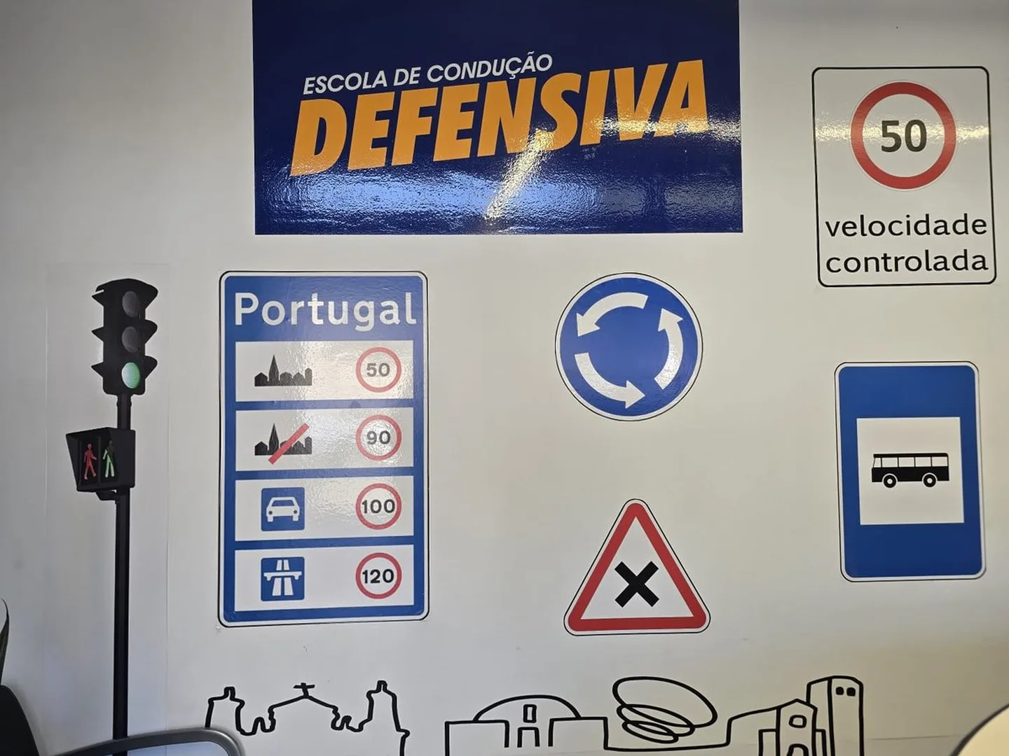 Parede de sinais da escola: limites de velocidade em Portugal, rotunda, semáforo e o logótipo da escola