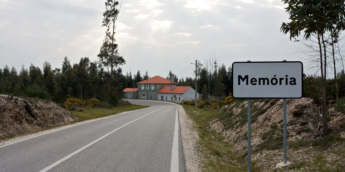 Estrada a chegar a uma localidade, com a placa de início de localidade